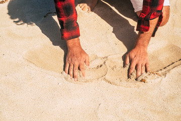 Sand beach and men hands touching and moving enjoying the summer - concept of holiday vacation and traveler people - enjoying outdoor leisure activity at the sea side