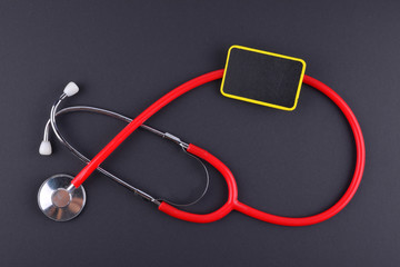 Stethoscope on black background with text. MEDICAL CONCEPT