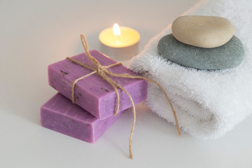 Fototapeta na wymiar white towels with candle,flower,stones and soap for hotel spa concept.