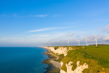 Quatre éoliennes dans un champ normand au bord de la mer