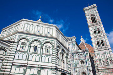Fototapeta premium Baptistery of St. John, Giotto Campanile and Florence Cathedral consecrated in 1436 against a beautiful blue sky