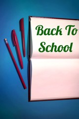 back to school open book with red pencil and pen on blue background
