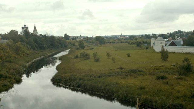 Village landscape with a water creek - church on a background - Suzdal, Russia