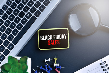 Keyboard with magnifying glass on black background with text BLACK FRIDAY SALES