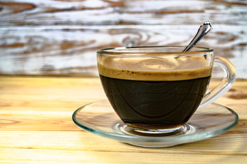 glass cup with espresso on a wooden table close-up