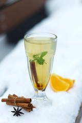 glass of hot vitamin tea on winter snowy bench. winter hot seasonal drinks