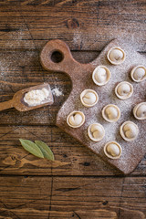 Raw Russian traditional dumplings on wooden background