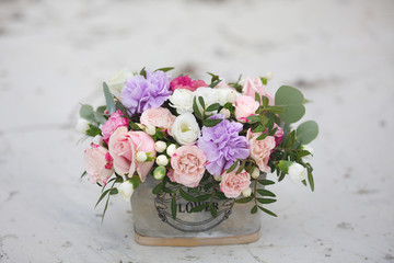 Flower arrangement in a box with spray pink roses, succulent, eustoma, white hypericum, eucaliptus.