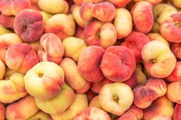 Ripe juicy peaches in a box in a supermarket. Close-up. Background. Space for text.