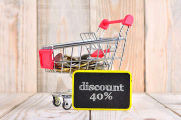 Trolley and coins with sale concept