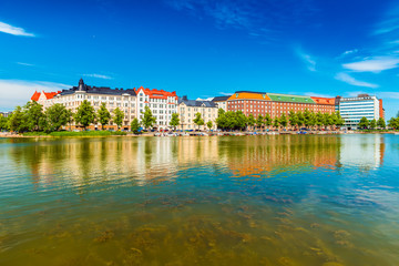 Cityscape of Helsinki reflected in water. Historical buildings with blue sky on the background, Finland