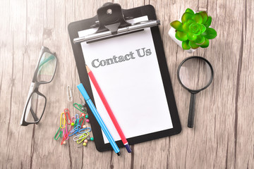 Clipboard with text written on paper - Contact Us