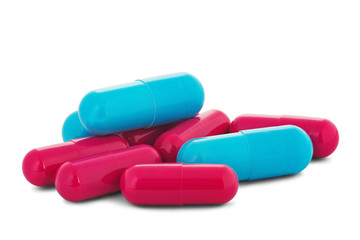 Pile of medical pills in red and blue colors on white isolated background with shadow.
