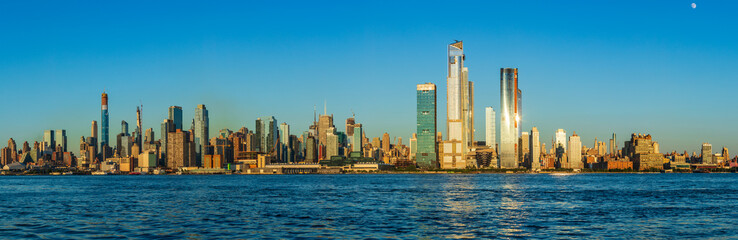View to Manhattan skyline from Weehawken Waterfront in Hudson River at sunset.