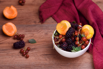 Ripe and tasty berries in white bowl on the table