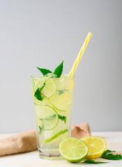 Cooling lemonade with lemon and lime, slices of ginger and mint leaves.