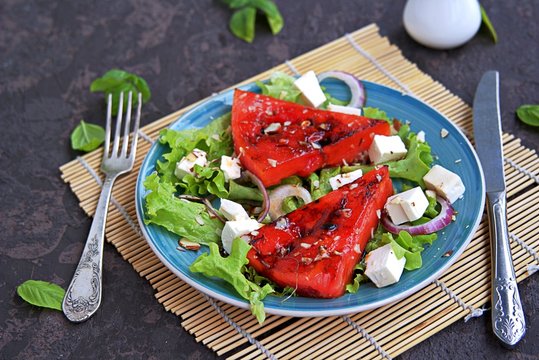 Summer salad of watermelon grilled, feta cheese and onions. Dressed with balsamic vinegar and olive oil. Selective focus. Healthy food.