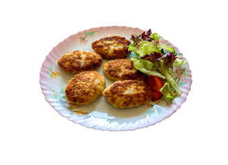 Delicious fresh fried homemade fish cakes on white plate with parsley, dill, and lemon, classic recipe with different species of edible fish, view from above