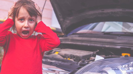 Humorous photo of beautiful little child girl open hood of her broken car. She having panic attack.