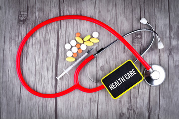 Pills, Syringe and Stethoscope with text Health Care