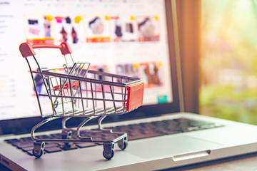 Shopping online concept - shopping cart or trolley on a laptop keyboard. Shopping service on The online web.