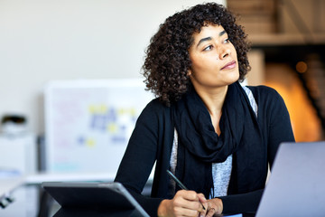 Thoughtful businesswoman sitting at desk in office