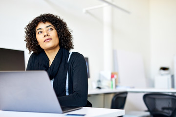Thoughtful businesswoman sitting at desk in office