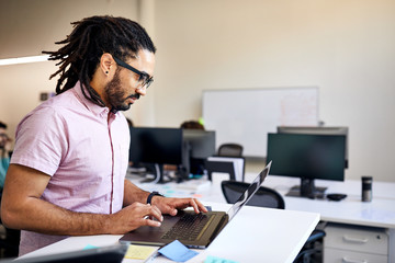 Side view of businessman using laptop in office