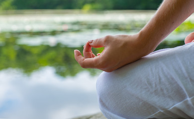 Close-up female hand in lotus position. Woman practicing yoga and meditating.