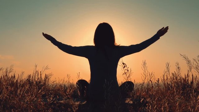 silhouette woman meditating beautiful view on rising sun outdoors sport for flexibility and calm