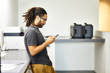 Side view of businessman using smartphone in office