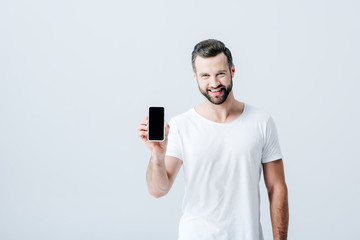 happy man showing smartphone with blank screen isolated on grey