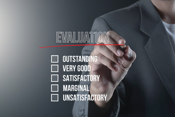 Hand of business man write or writing EVALUATION