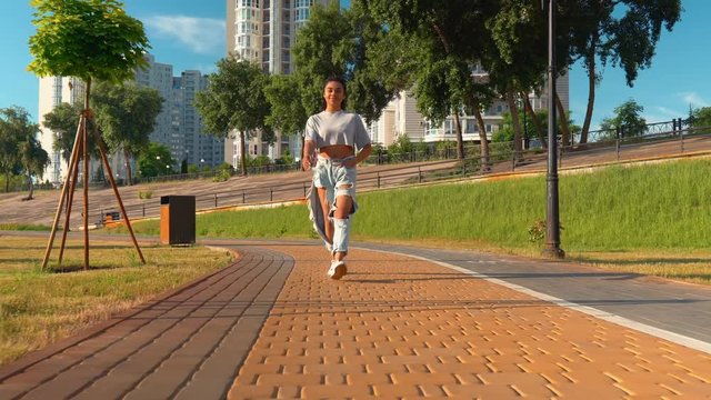 young african woman walking in residential area on the background multi flat houses teeager wearing casual jeans and t-shirt walks in sunny day summer season