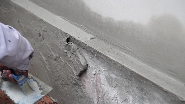Construction worker plaster cement wall footage slow motion