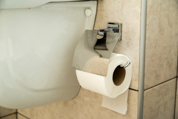 white toilet paper on a wall-mounted holder