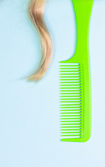 COMB AND HAIR ON LIGHT BLUE BACKGROUND