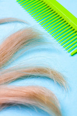COMB AND HAIR ON LIGHT BLUE BACKGROUND
