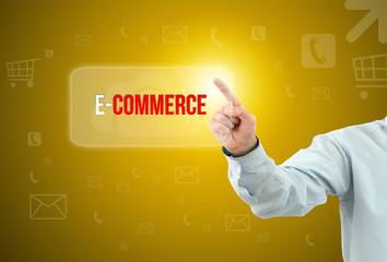 Business man touch a button on an imaginary screen with text E-COMMERCE