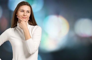 Pretty young thoughtful woman on background
