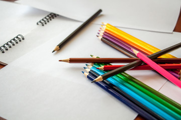 Fototapeta premium colored pencils are lying on white sheets of paper