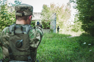 military in the form of aiming and trying to shoot a gun. rear view