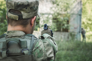 military in the form of aiming and trying to shoot a gun. rear view