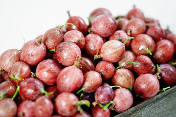 Gooseberries in basket on wooden background close-up