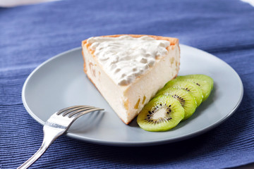 Homemade cottage cheese and semolina cake with kiwi fruit and cream on a plate