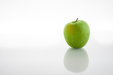 One green apples isolated on white background with reflex on glass