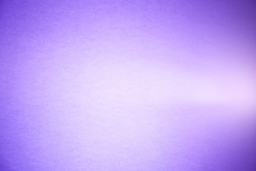 A bright ray of light cuts through the textural wide-and semi-blurred purple background