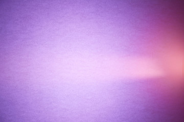 Light pink ray of light cuts pink semi-blurred and purple textural background