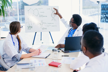 Professional group of multi racial doctors or interns with mentor have a meeting and making notes...