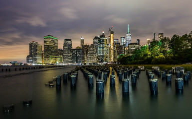 Fototapeta na wymiar Manhattan panoramic skyline at night from Brooklyn Bridge Park. New York City, USA. Office buildings and skyscrapers at Lower Manhattan (Downtown Manhattan)..